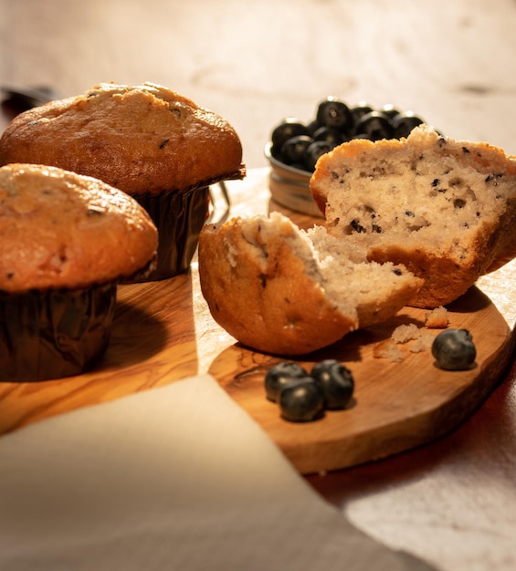 Muffin casa nade con i mirtilli sul tagliere di legno.