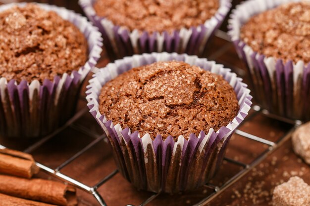 Muffin casalinghi del caffè con il primo piano dello zucchero bruno e della cannella