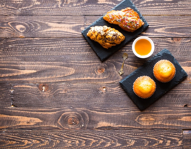 Muffin casalinghi deliziosi con yogurt, su un fondo di legno con spazio per testo.