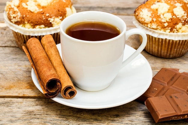 Muffin con bastoncini di cannella e cioccolato su un tavolo di legno