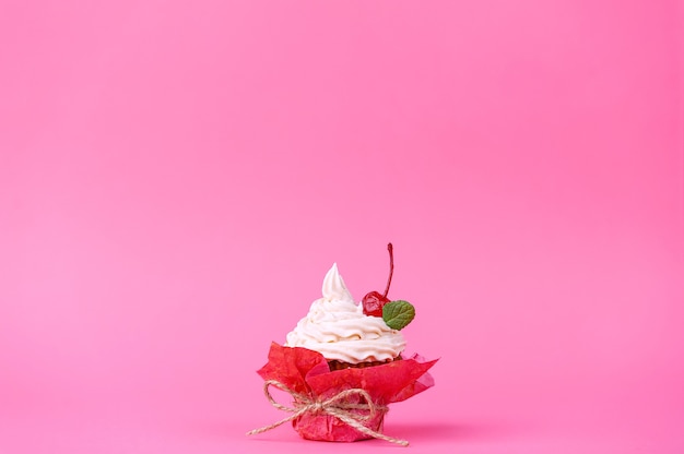 Muffin con crema su sfondo rosa.