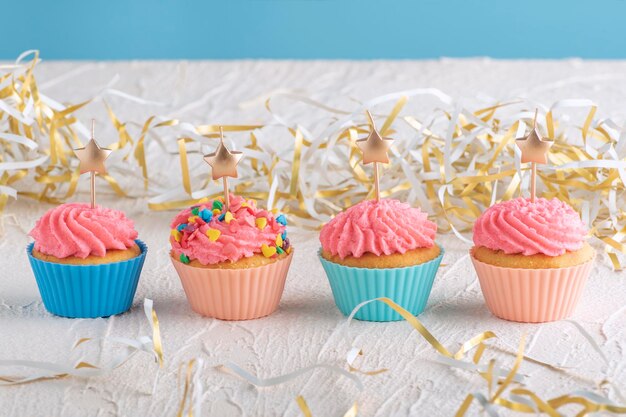 Muffin con glassa al burro rosa con candela a forma di stella. Cibo delizioso per le feste.