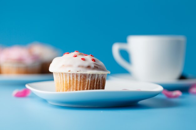 Muffin con glassa su un piatto e una tazza