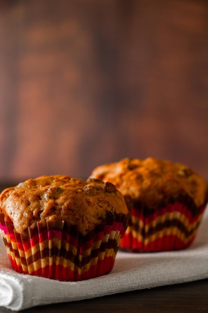 Muffin con uvetta su uno sfondo di legno Cupcake in uno stampo di carta su un tovagliolo bianco