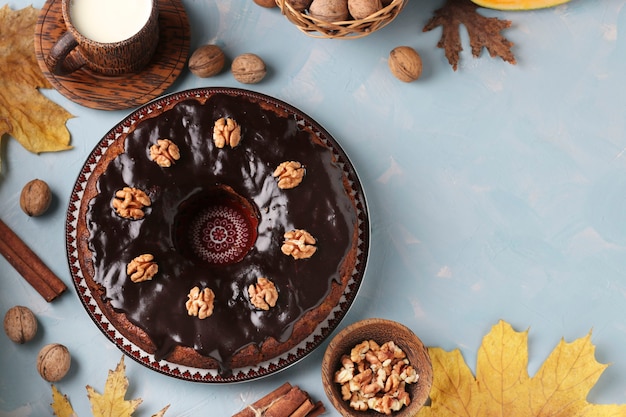 Muffin di zucca fatti in casa decorati con glassa al cioccolato e noci su fondo azzurro