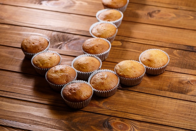 Muffin fatti in casa avvolti in carta su tavola di legno