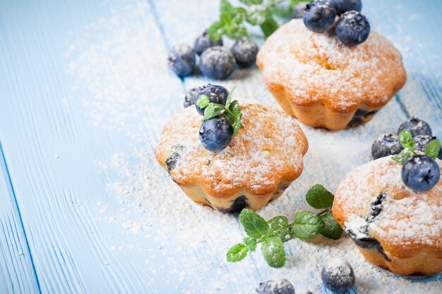 Muffin fatti in casa con mirtilli, bacche fresche, zucchero a velo