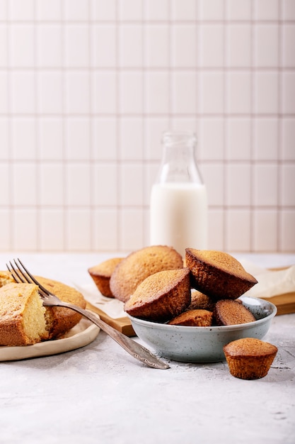 Muffin fatti in casa serviti con latte in una bottiglia su priorità bassa bianca di struttura