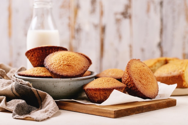 Muffin fatti in casa serviti con latte in una bottiglia su priorità bassa bianca di struttura