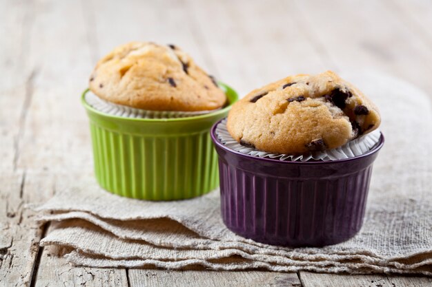 Muffin freschi fatti in casa su ciotole di ceramica sul tovagliolo di lino.