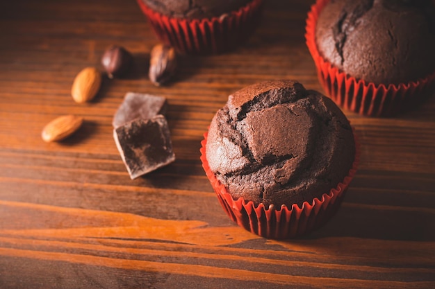 Muffin o cupcakes al cioccolato fatti in casa su una tavola di legno