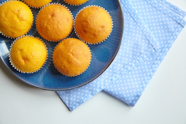 Muffin sulla zolla blu sul tavolo da pranzo con il tovagliolo