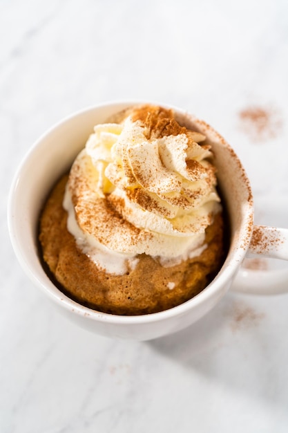 Mug cake alla zucca guarnito con panna montata fatta in casa e cannella