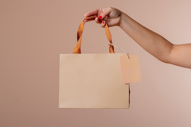 Mujer joven sosteniendo una borsa di regalo per vacanze, regali e feste.