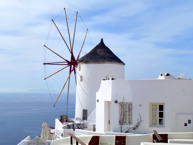 Mulino a vento tradizionale greco di stile e villa bianca al villaggio di OIA sull&#39;isola di Santorini, Grecia