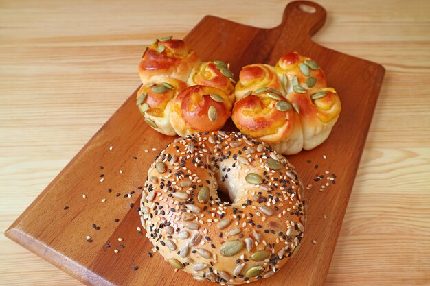 Multi grani e bagel di sesamo e rotoli su tagliere di legno