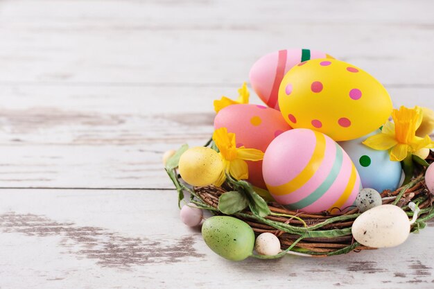 Multi uova di Pasqua colorate nel nido su fondo in legno Cartolina d'auguri di buona Pasqua