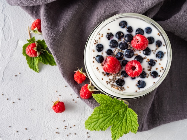 Munga lo yogurt con i mirtilli, i lamponi, la disintossicazione. Copia spazio.