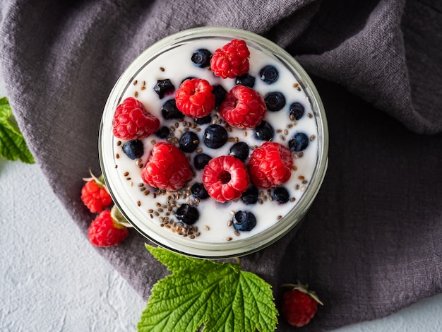 Munga lo yogurt con i mirtilli, i lamponi, la disintossicazione. Copia spazio.