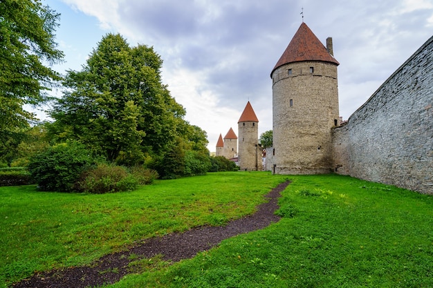 Mura medievali con alte torri in pietra e tetti rossi a Tallinn Estonia.