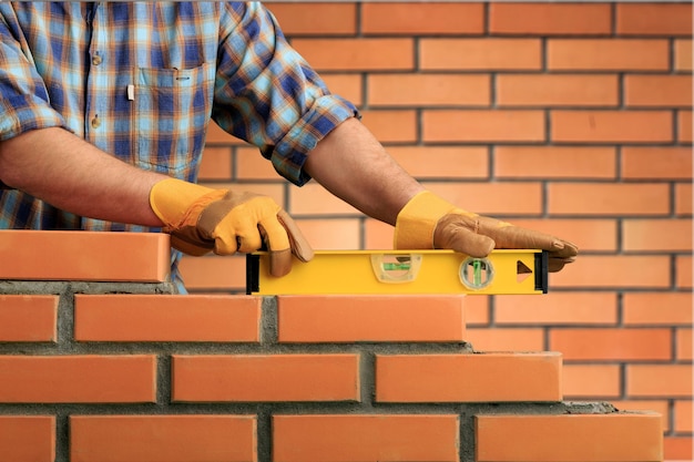 Muratore in muratura di cemento costruisce un lavoratore della casa a strati