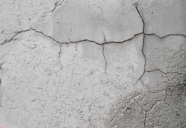 Muro bianco di cemento incrinato ricoperto di struttura di cemento grigio come sfondo