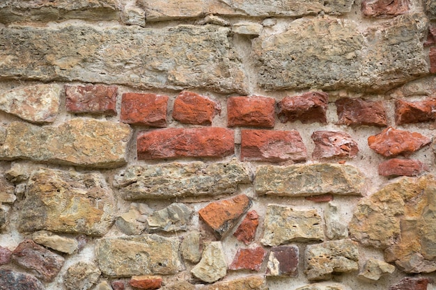 Muro del castello medievale con pietre e mattoni rossi