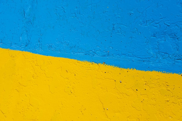 Muro di cemento dipinto in giallo e blu come la bandiera ucraina del paese vittima dell'aggressore