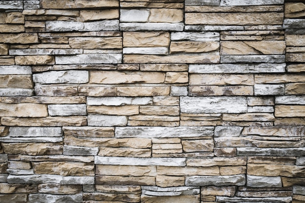 Muro di mattoni marrone grigio. Texture di pietra, sfondo