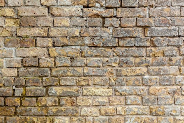 Muro di mattoni Muro di mattoni con mattoni di diverse dimensioni e forma di colore sabbia con aggiunta