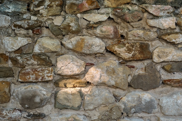 Muro di pietra, vecchio muro di pietra fatiscente in pietra e arenaria, sfondo natura astratta