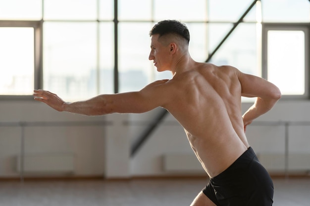 Muscoloso uomo latino che si allena in palestra facendo yoga Tecniche di karate sport corpo