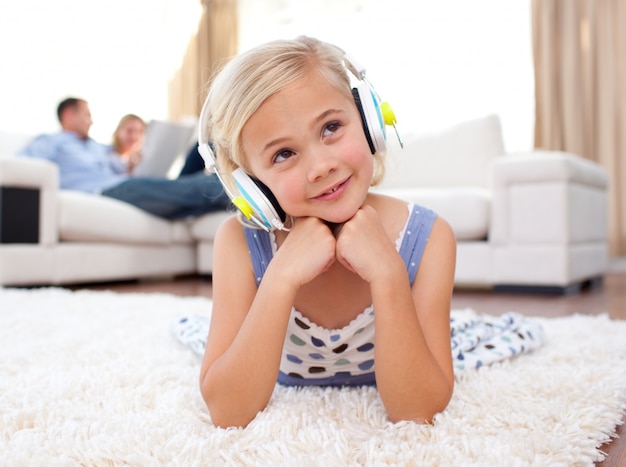 Musica d&#39;ascolto della bambina adorabile che si trova sul pavimento