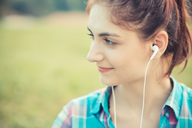 musica d&#39;ascolto della bella giovane donna dei pantaloni a vita bassa