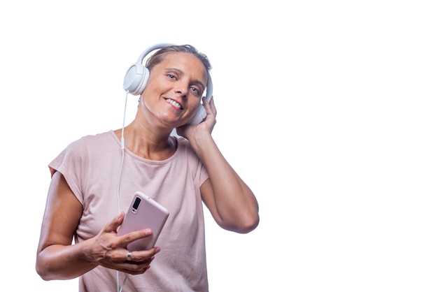 Musica d'ascolto della donna allegra con lo smartphone che guarda l'obbiettivo