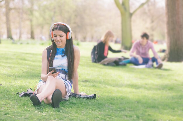 Musica d&#39;ascolto della giovane donna al parco a Londra