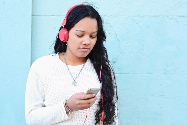 Musica d&#39;ascolto della giovane donna e per mezzo del suo smartphone.