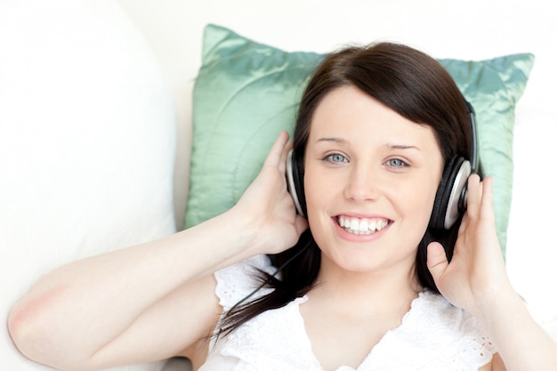 Musica d&#39;ascolto sorridente della giovane donna con le cuffie