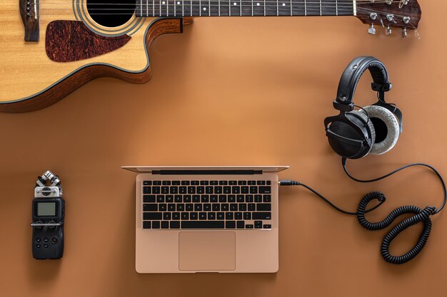 Musica di sottofondo con cuffie, laptop e chitarra flat lay