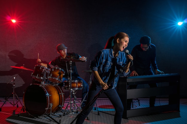 Musicista band mano tenendo il microfono e cantando una canzone e suonando strumenti