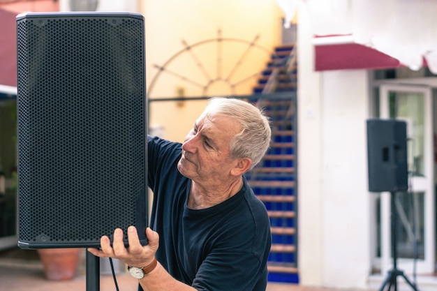 Musicista che installa l'altoparlante su un palco su una terrazza