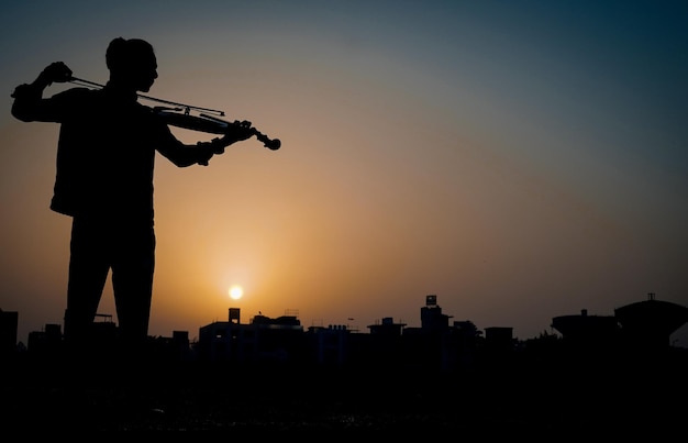 Musicista che suona il violino. Musica e concetto di tono musicale. immagini di silhouette di uomo musicista