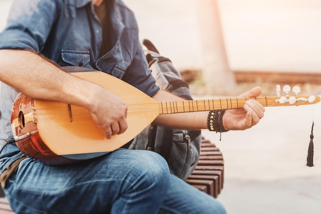 Musicista di strada che esegue canzoni popolari e suona su un tradizionale ottomano e baglama turco e strumento a corde saz