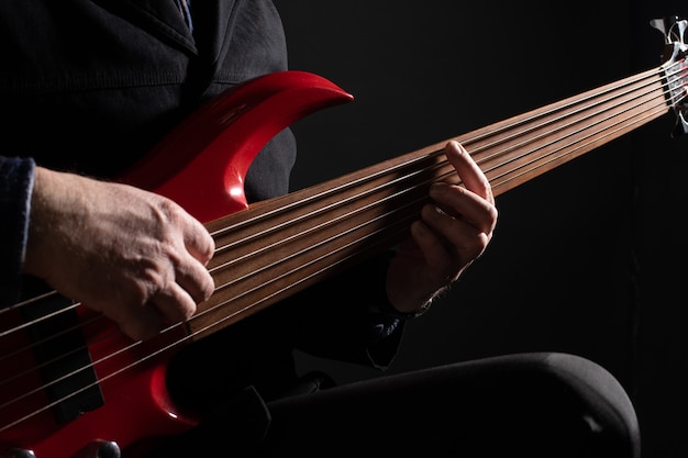 Musicista maschio che suona il basso fretless a sei corde