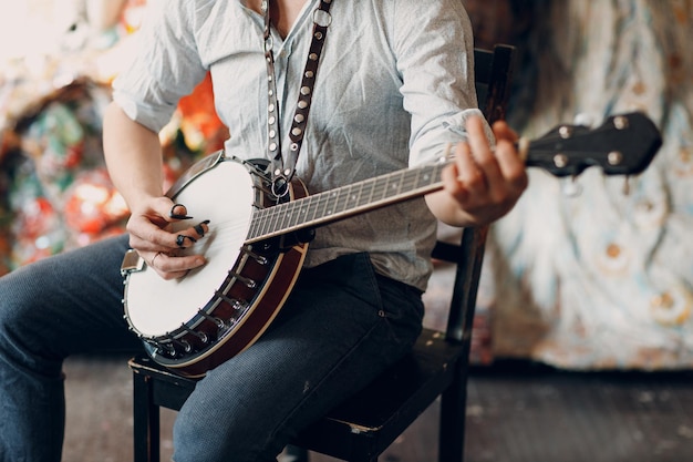 Musicista maschio che suona la sedia di seduta del banjo dell'interno