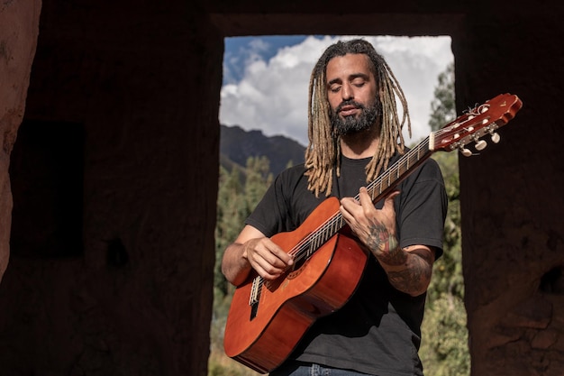 Musico tocando una guitarra en un centro arqueolgico en Cusco Perù