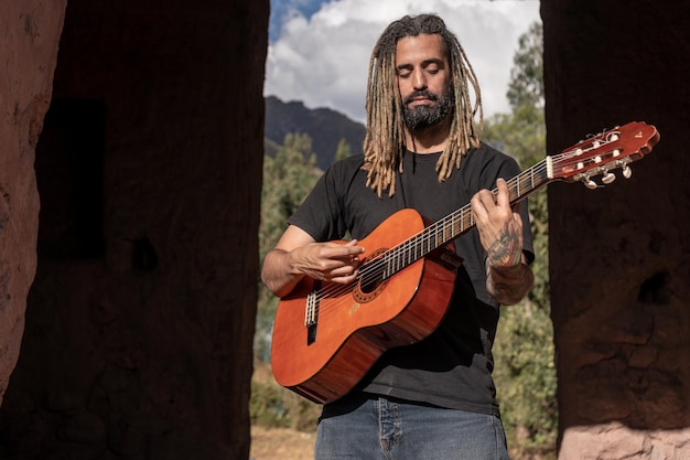 Musico tocando una guitarra en un centro arqueolgico en Cusco Perù