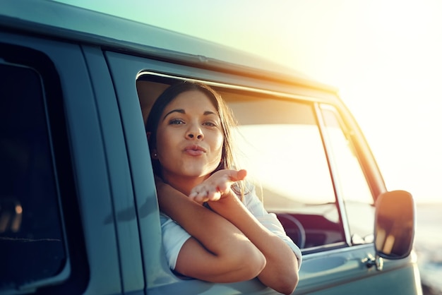 Mwah Ci vediamo quando torno Inquadratura di una giovane donna che si sporge dal finestrino di un furgone e si bacia durante un viaggio