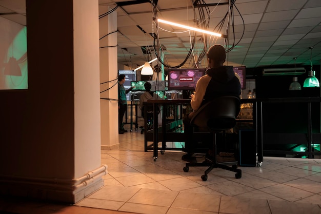 Mysterious spy planning security breach with virus, hacking computer server and breaking firewall encrytion. Male hacker working to steal government information late at night, cyberterrorism.