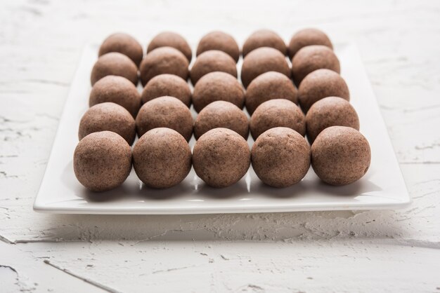 Nachni laddu o Ragi laddoo o palline fatte con miglio, zucchero e burro chiarificato. È un alimento salutare dall'India. Servito in una ciotola o piatto con crudo intero e polvere. Messa a fuoco selettiva